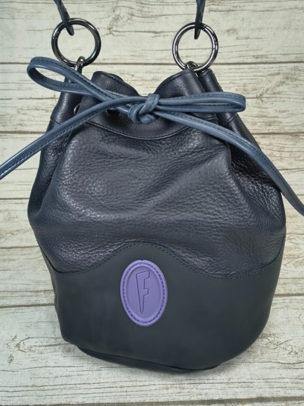 John Fluevog Navy Pebbled Leather Drawstring Bucket Bag Purple F Logo